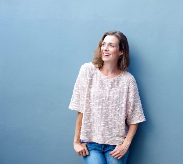 Happy woman smiling on gray background